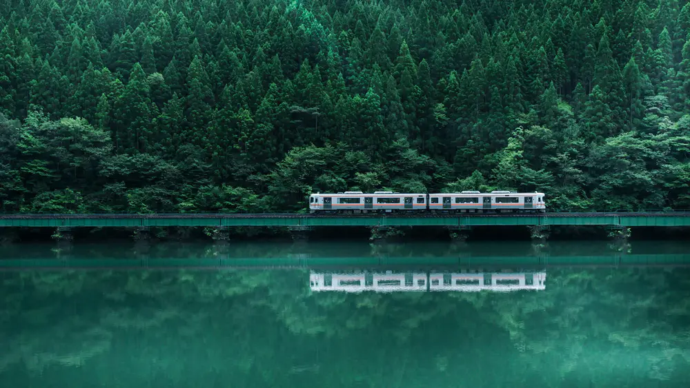 宁静湖面上的列车与森林壁纸